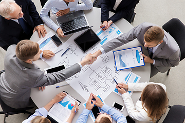 Image showing businessmen making handshake at office