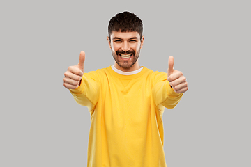 Image showing smiling young man showing thumbs up