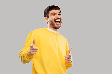 Image showing smiling young man showing thumbs up