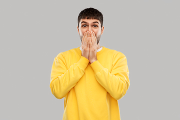Image showing shocked young man covering his mouth with hands