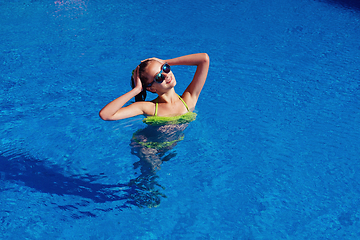 Image showing teen girl relaxing near swimming pool