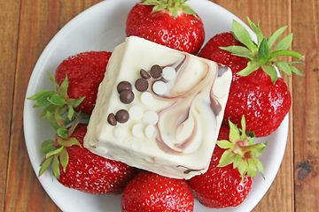 Image showing ripe red strawberries on the white plate and cake