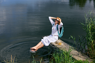 Image showing Young woman resting near lake