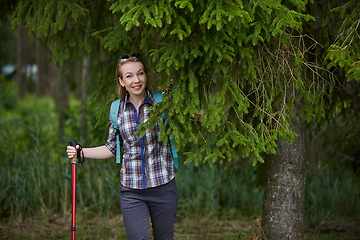 Image showing young woman with nordic walk pols