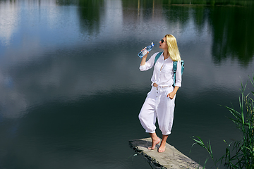 Image showing Young woman resting near lake