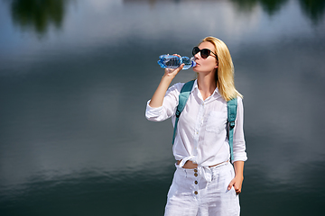 Image showing Young woman resting near lake