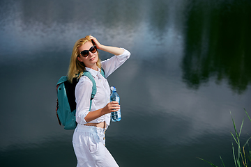 Image showing Young woman resting near lake