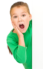 Image showing Little girl is looking out from the blank banner