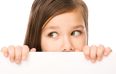 Image showing Little girl is looking from out blank board