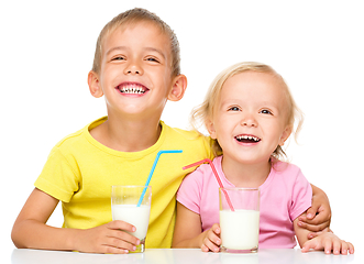 Image showing Cute little girl and boy are drinking milk