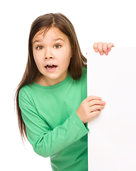 Image showing Little girl is looking out from the blank banner