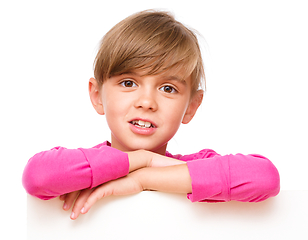 Image showing Little girl is looking out from the blank banner