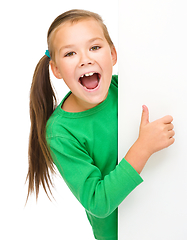 Image showing Little girl is looking from out blank board