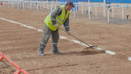 Image showing The worker rakes the sand with rakes. UltraHD stock footage