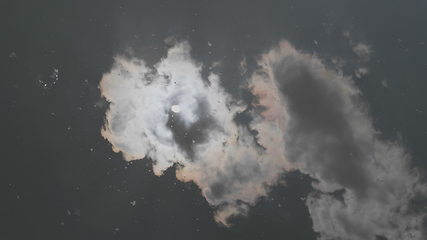 Image showing Clouds and sun reflected in the lake water.