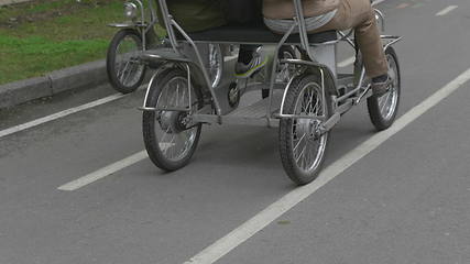 Image showing View of legs of man cycling in city park area.