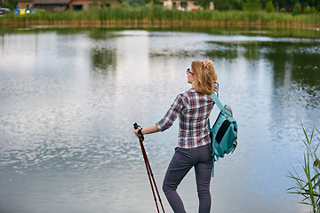 Image showing young woman with nordic walk pols