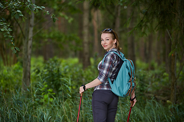 Image showing young woman with nordic walk pols