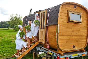 Image showing three girls relaxing outside sauna