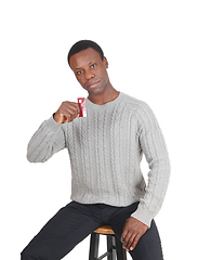 Image showing African man holding up his credit card
