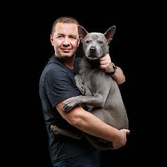 Image showing man holding thai ridgeback dog