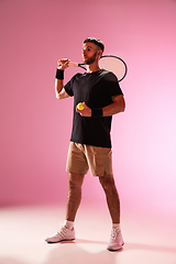 Image showing Young caucasian man playing tennis isolated on pink studio background, action and motion concept