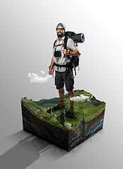 Image showing Travel and vacation concept. Traveler on cut of the ground and the grass landscape with the cut of the mountain field.