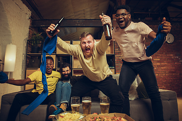 Image showing Group of friends watching TV, sport match together. Emotional fans cheering for favourite team, watching on exciting game.