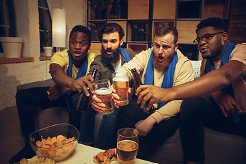 Image showing Group of friends watching TV, sport match together. Emotional fans cheering for favourite team, watching on exciting game.