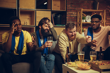 Image showing Group of friends watching TV, sport match together. Emotional fans cheering for favourite team, watching on exciting game.