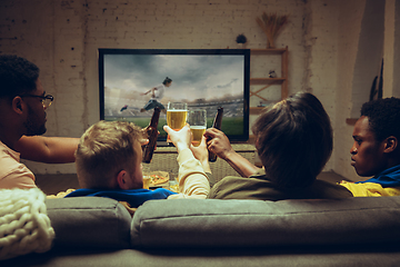 Image showing Group of friends watching TV, sport match together. Emotional fans cheering for favourite team, watching on exciting game.