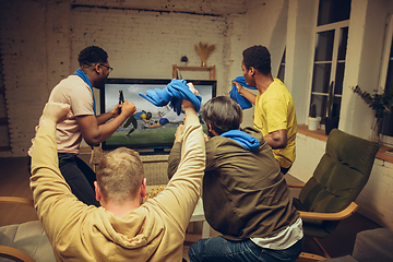 Image showing Group of friends watching TV, sport match together. Emotional fans cheering for favourite team, watching on exciting game.