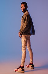 Image showing Young stylish man in modern street style outfit isolated on gradient background in neon light. African-american fashionable model in look book, musician performing.