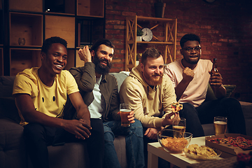 Image showing Group of friends watching TV, sport match together. Emotional fans cheering for favourite team, watching on exciting game.