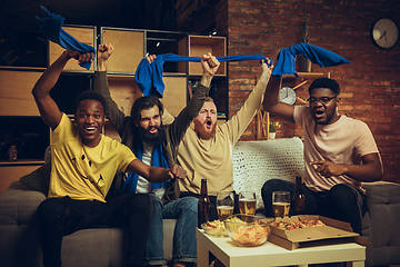 Image showing Group of friends watching TV, sport match together. Emotional fans cheering for favourite team, watching on exciting game.