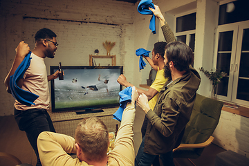 Image showing Group of friends watching TV, sport match together. Emotional fans cheering for favourite team, watching on exciting game.