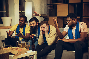 Image showing Group of friends watching TV, sport match together. Emotional fans cheering for favourite team, watching on exciting game.