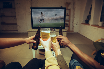 Image showing Group of friends watching TV, sport match together. Emotional fans cheering for favourite team, watching on exciting game.