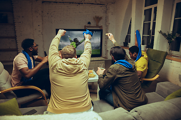 Image showing Group of friends watching TV, sport match together. Emotional fans cheering for favourite team, watching on exciting game.