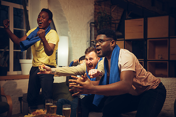 Image showing Group of friends watching TV, sport match together. Emotional fans cheering for favourite team, watching on exciting game.