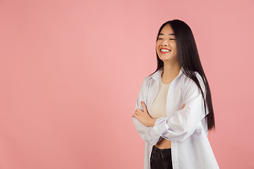 Image showing Asian young woman\'s portrait on pink studio background. Concept of human emotions, facial expression, youth, sales, ad.