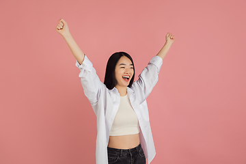 Image showing Asian young woman\'s portrait on pink studio background. Concept of human emotions, facial expression, youth, sales, ad.