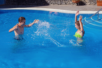 Image showing boy and girl having fun in swimming pool