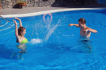 Image showing boy and girl having fun in swimming pool