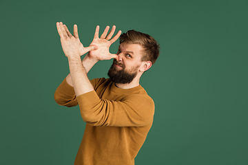 Image showing Caucasian man\'s portrait isolated over green studio background with copyspace