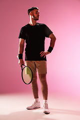 Image showing Young caucasian man playing tennis isolated on pink studio background, action and motion concept