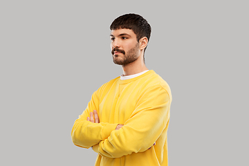 Image showing young man in yellow sweatshirt with crossed arms