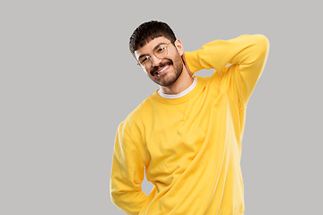 Image showing smiling young man in glasses and yellow sweatshirt