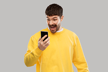 Image showing happy smiling young man with smartphone