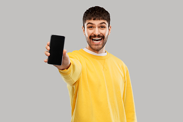 Image showing happy smiling young man showing smartphone